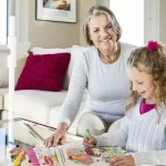 A superpole with superbar is installed next to a sofa while an elderly woman plays with her granddaughter.